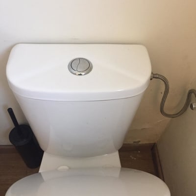 אסלה עם מכסה פתוח וצינור מים מחובר