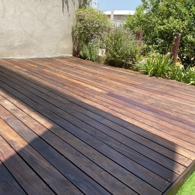 דק עץ בגינה עם צמחים מסביב