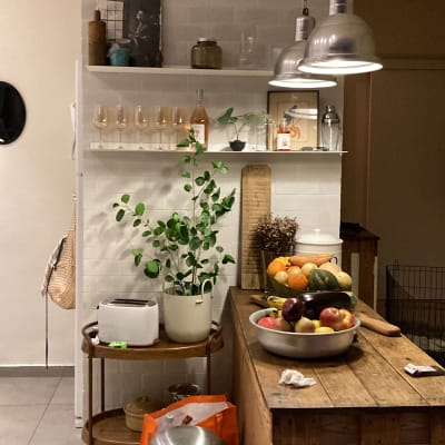 מטבח עם מדף כלים, פירות על השולחן, תאורה תלויה