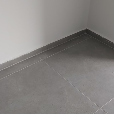 רצפה נקייה עם אריחים אפורים ליד דלת