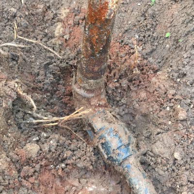 צינור חלוד באדמה עם חיבור