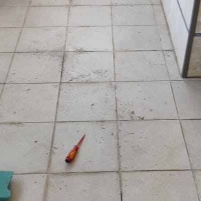 מברג על רצפה ליד ארגז כלים כחול