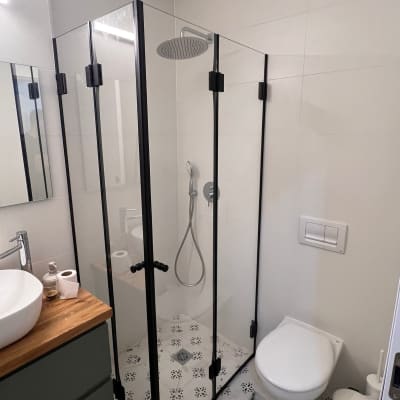 מקלחון זכוכית עם ראש מקלחת עגול ומוט תלייה