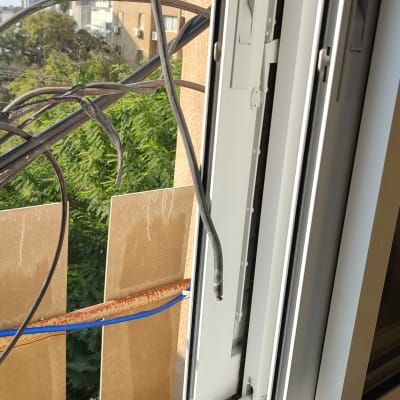 כבלים שחורים מחוברים לחלון ליד דוד שמש