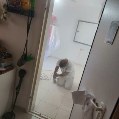 אדם כורע על ברכיו ומשתמש בכלי עבודה על רצפה