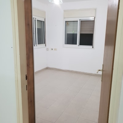 חדר ריק עם קירות לבנים ותאורה עליונה