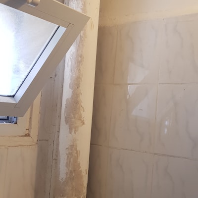 צינור לבן עם סימני רטיבות על הקיר