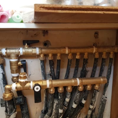 צינורות פליז עם ברזים מתחת לכיור