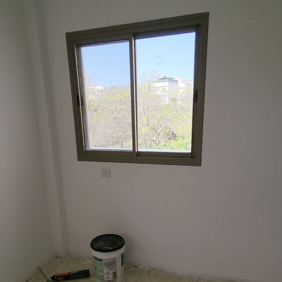 דלי צבע וכלי עבודה על רצפה בחדר ריק