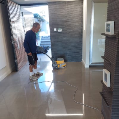 אדם מנקה רצפה עם מכונת פוליש חשמלית