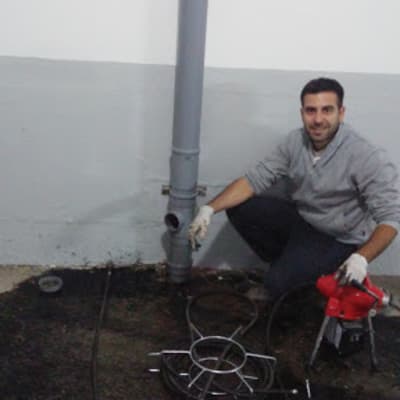 אדם עם כלי עבודה ליד צינור ביוב