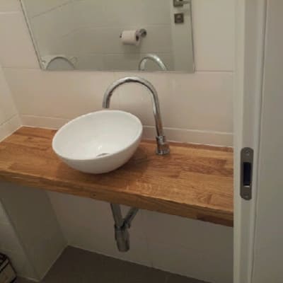 כיור עגול על משטח עץ בחדר אמבטיה