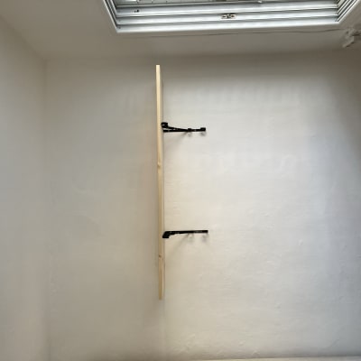 מדף עץ מותקן על קיר עם תומכים שחורים