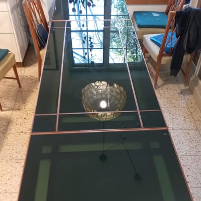 שולחן זכוכית עם מסגרת מתכת בחדר אוכל מואר