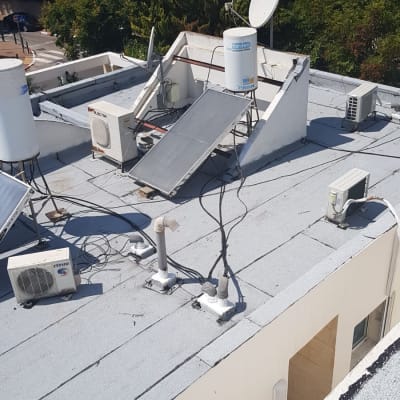 גג עם קולטי שמש ודודי מים, צינורות ואיטום גג