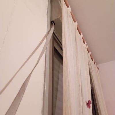 תריסים סגורים עם וילון לבן בצד