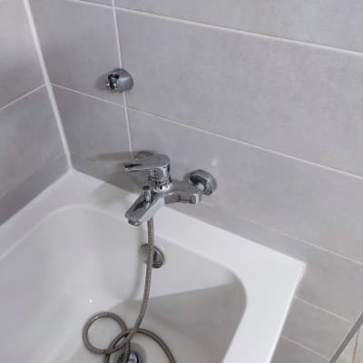 ברז אמבטיה עם צינור גמיש על קיר אריחים