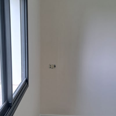 קיר צבוע בלבן עם חלון שחור