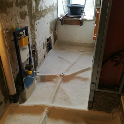 חדר בשיפוץ עם קירות חשופים ודלי תלוי בשרשראות