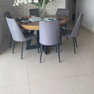 שולחן עגול עם כיסאות אפורים ופרחים באגרטל