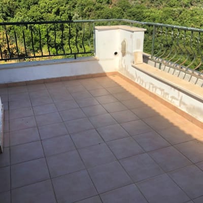 מרפסת עם רצפת אריחים ומעקה מתכת