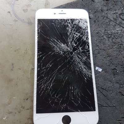 אייפון עם מסך שבור על שולחן עבודה