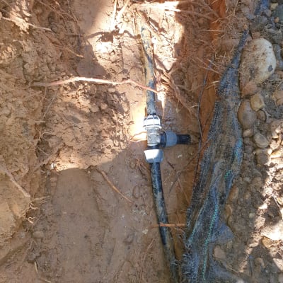 צינור מים עם מחבר מתכת באדמה