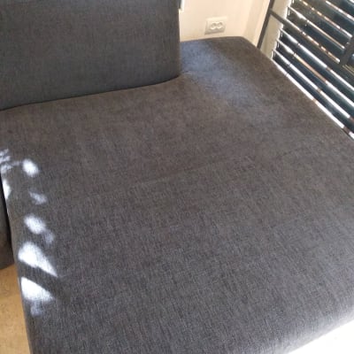 ספה אפורה נקייה ליד חלון עם תריסים