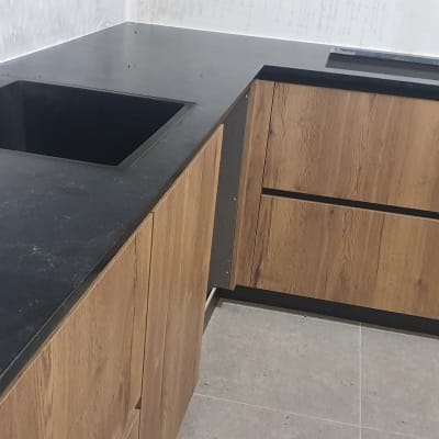 משטח שיש כהה עם כיור מובנה במטבח מודרני