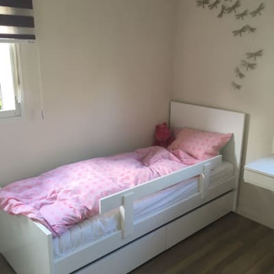 מיטה לבנה עם מעקה בחדר ילדים