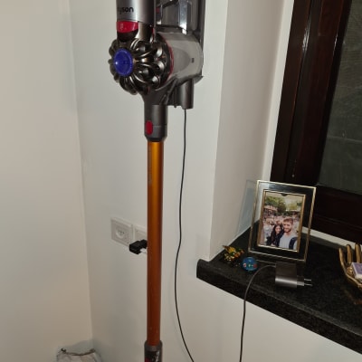 שואב אבק אלחוטי תלוי על הקיר עם מטען