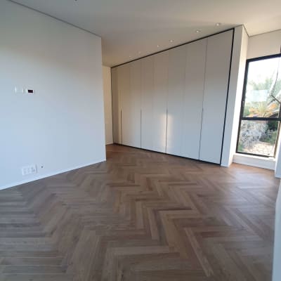 חדר ריק עם רצפת פרקט נקייה וארון קיר