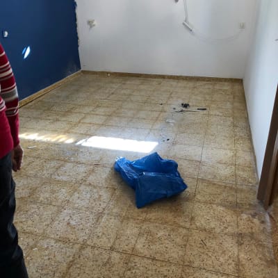 רצפת אריחים בחדר ריק עם שקית כחולה