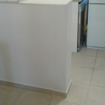 קיר לבן חדש עם אריחי רצפה בהירים