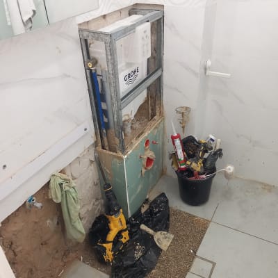 שיפוץ חדר אמבטיה עם כלים וחומרים על הרצפה