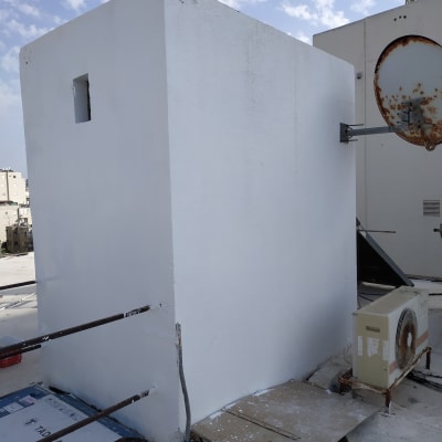 קיר צבוע בלבן עם כתמי צבע על הרצפה