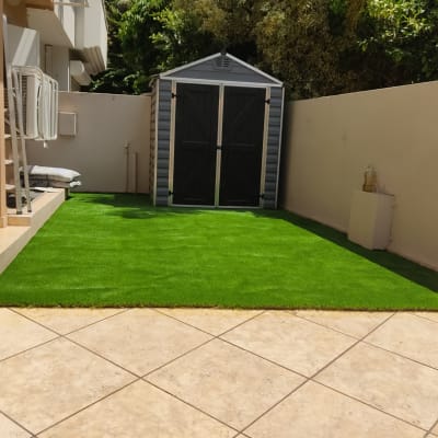 מחסן גינה על דשא סינתטי ירוק