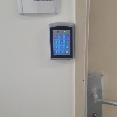 לוח מקשים מואר ליד דלת עם ידית מתכת