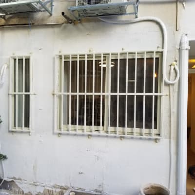 חלונות עם סורגים לבנים על קיר חיצוני