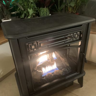 תנור גז שחור עם אש בוערת בפנים