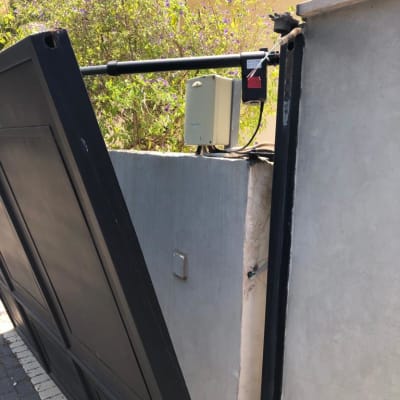 שער מתכת שחור עם מנגנון פתיחה חשמלי