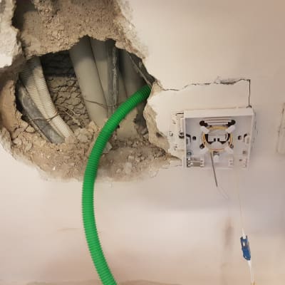 חוטי חשמל ותקשורת בקיר עם שקע פתוח