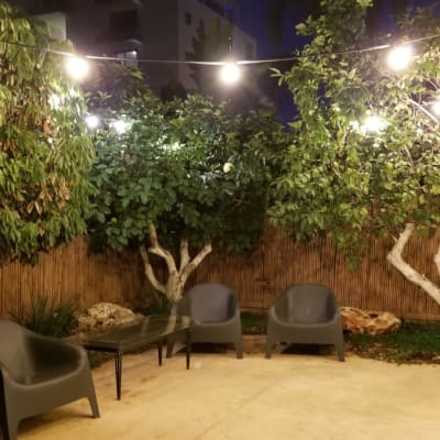 אורות תלויים על חוטים בגינה מוארת בלילה