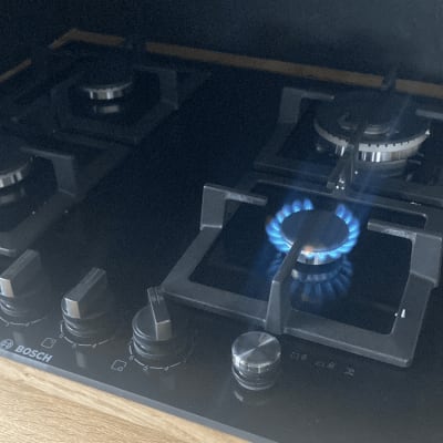 כיריים גז עם להבה דולקת ומתגי שליטה