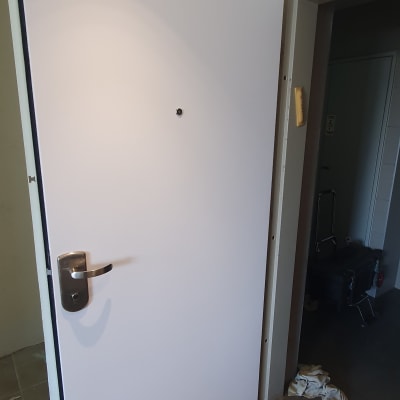 דלת לבנה עם ידית מתכת מותקנת