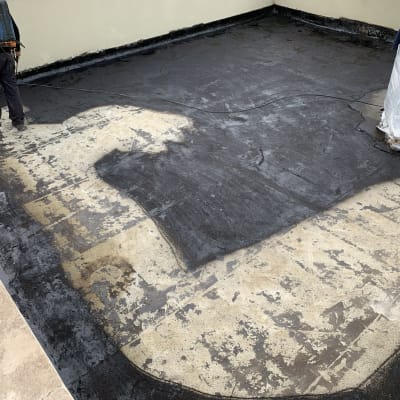 אדם מורח חומר איטום על גג שטוח