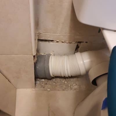 צינור פלסטיק לבן מחובר לקיר עם חור