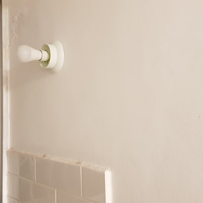 נורה חשמלית מותקנת על קיר לבן