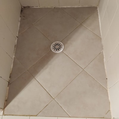 רצפת מקלחת עם אריחים וניקוז במרכז