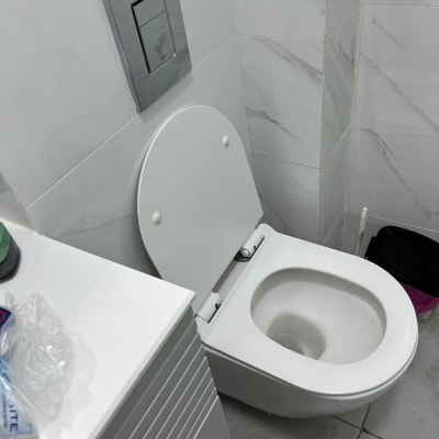 אסלה מותקנת בחדר אמבטיה עם אריחים חדשים